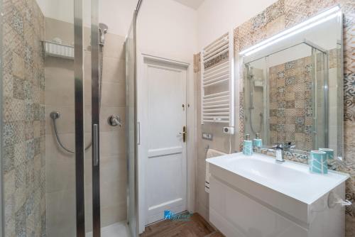 a bathroom with a sink and a shower and a mirror at Mica apt in Alghero