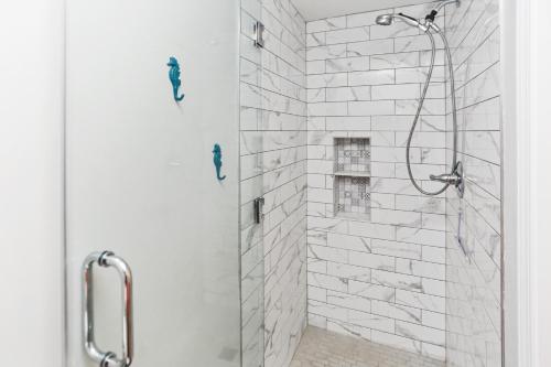 W łazience znajduje się prysznic z białą ceglaną ścianą. w obiekcie Club at Mexico Beach 2C Coastal Dreaming by Pristine Properties Vacation Rentals w mieście Mexico Beach