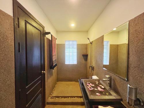 a bathroom with a black door and a sink at The Bliss Angkor in Siem Reap