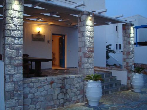 a house with a stone wall and a patio at Glaronisia Hotel in Pollonia