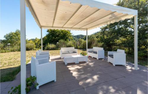 a pavilion with white chairs and tables on a patio at La Casa Di Valcerosa in Apecchio