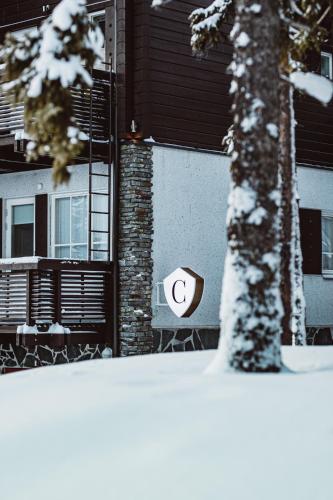 a sign on the side of a house in the snow at Levin Alppitalot Alpine Chalets Deluxe in Levi