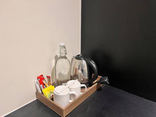 a tray with a tea kettle and cups on a table at Hotel Aman Kuala Lumpur in Kuala Lumpur