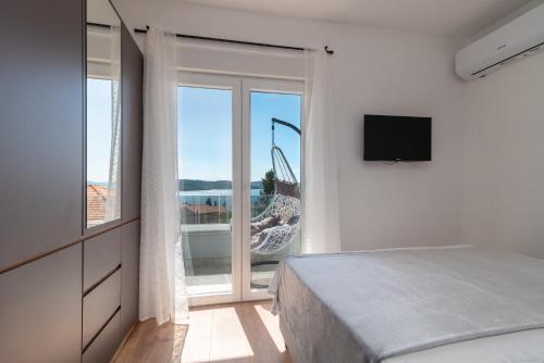 a bedroom with a bed and a large window at Villa Kuzmanić in Trogir