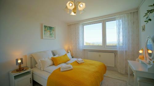 een slaapkamer met een bed met gele lakens en een raam bij Apartamenty Every Sky Nadrzeczna 14 Karpacz in Karpacz