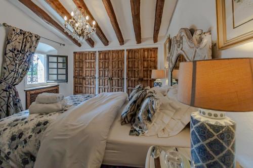 a bedroom with a large bed and a lamp at Masia Mimosa in Darnius