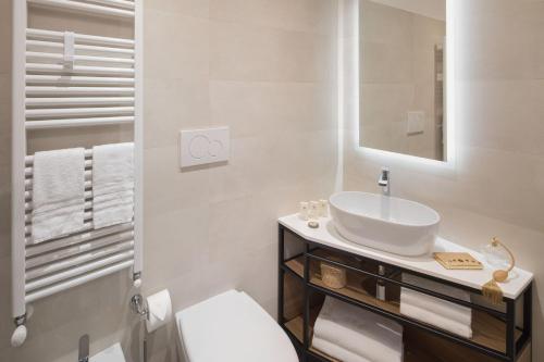 a white bathroom with a sink and a toilet at Hotel Vesuvio in Rapallo