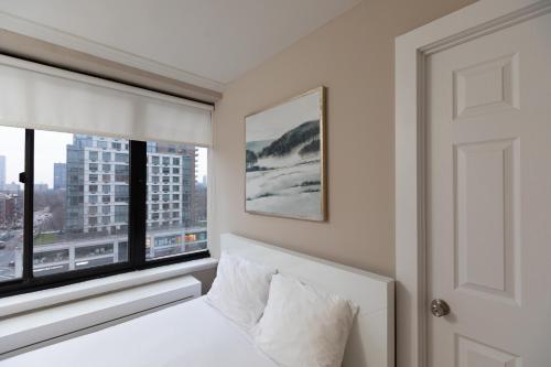 um quarto com uma cama branca e uma janela em Lovely 3 BR in NYC with Elevator em Nova York