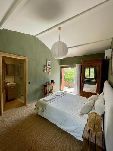 une chambre avec un grand lit blanc et une fenêtre dans l'établissement Beauregard Cévennes - Sublime chambre d'hôtes indépendante et moderne, à Monoblet
