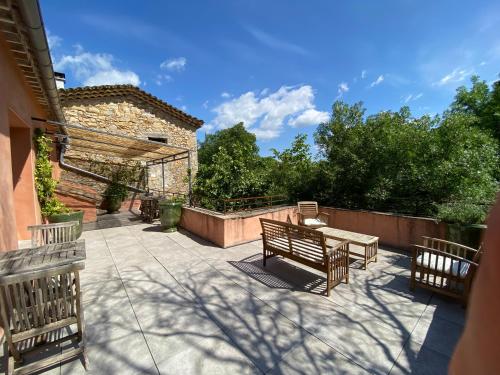 une terrasse avec deux bancs et une table en bois dans l'établissement Beauregard Cévennes - Sublime chambre d'hôtes indépendante et moderne, à Monoblet