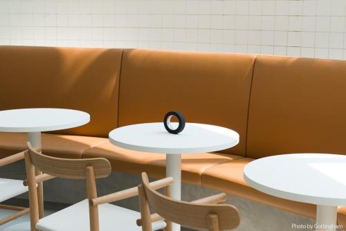 two tables and chairs with a black ring on them at KIRO Hiroshima by THE SHARE HOTELS in Hiroshima