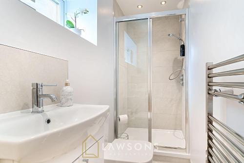 a white bathroom with a shower and a sink at Stylish Living by Lawsons with 3 Ensuites in Windsor