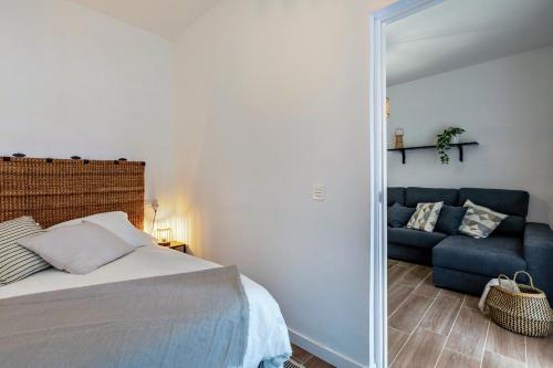 a bedroom with a bed and a blue couch at Apartment Santa Cruz Centro in Santa Cruz de Tenerife