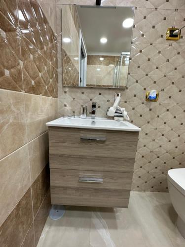 een badkamer met een wastafel, een spiegel en een toilet bij ChloeHouse in Napels