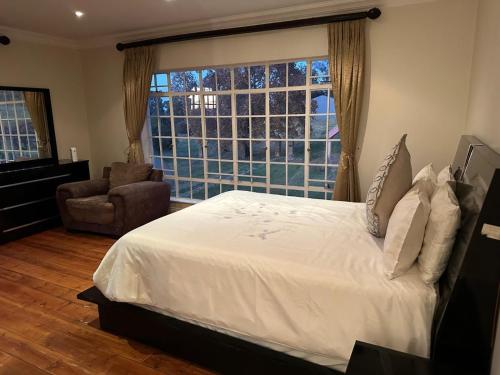 a bedroom with a bed and a large window at Thula Guest Farm in Clarens