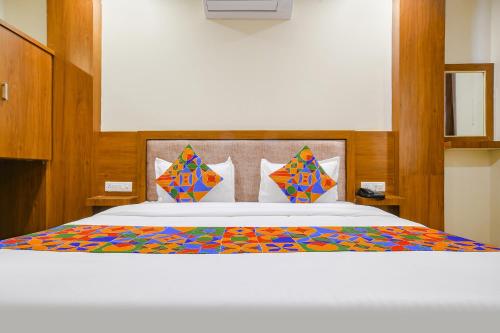 インドールにあるFabHotel Atharvのベッドルーム1室(カラフルな掛け布団付きのベッド1台付)