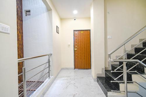 a hallway with a wooden door and stairs at FabHotel Atharv in Indore