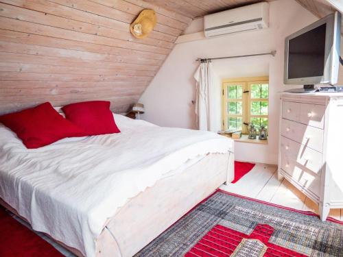 1 dormitorio con 1 cama blanca grande con almohadas rojas en Balatoncsicsó - Szőlő Birtok, en Balatoncsicsó