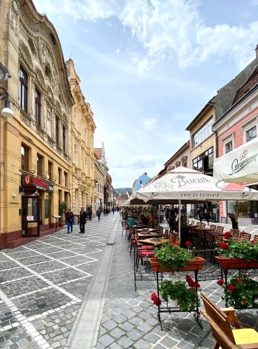 a city street with tables and chairs and buildings at Republique Apartment in Braşov