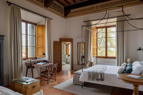a bedroom with a bed and a desk in a room at Precise Tale Poggio Alla Sala in Montepulciano