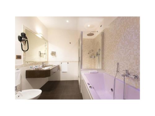 a bathroom with a pink tub and a sink at Hotel Nazionale in Rome