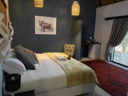 a bedroom with a bed with a bull on the wall at Selati River Ruins in Gravelotte