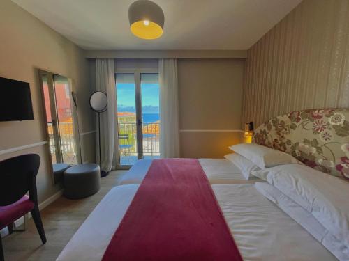 a bedroom with a large bed with a large window at Hotel Restaurant Christophe Colomb in Calvi