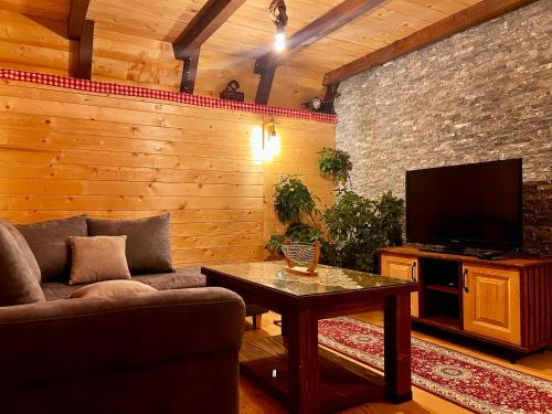 a living room with a couch and a tv at Etno Idila D&D in Žabljak