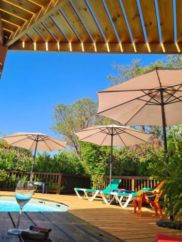 een patio met parasols en stoelen en een zwembad bij אמיתי נוף קסום in Moshav Ramot