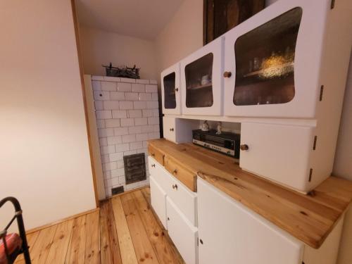 a kitchen with white cabinets and wooden floors at Dom u Elizy in Białystok