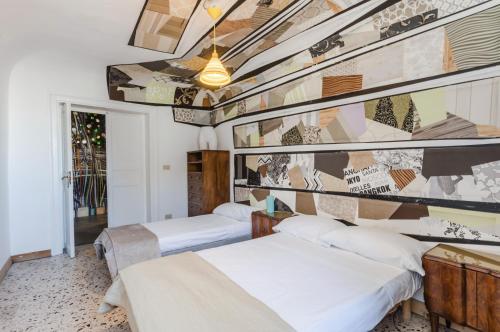 two beds in a room with a wall with a mural at Ballarò Market Street Art Stylish Flat x10 in Palermo