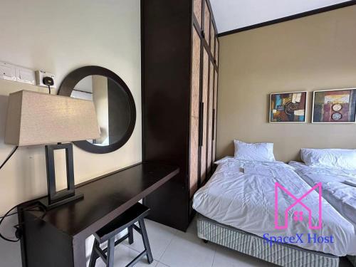 a bedroom with a bed and a desk with a mirror at Gold Coast Morib Resort in Banting