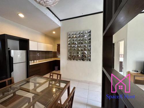a kitchen with a glass table and a refrigerator at Gold Coast Morib Resort in Banting