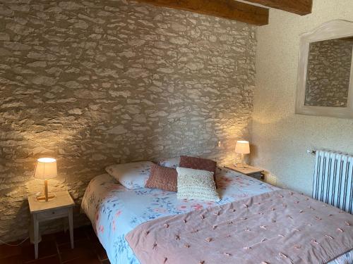 een slaapkamer met een bed en twee lampen op tafels bij Coulonges in Savignac-sur-Leyze