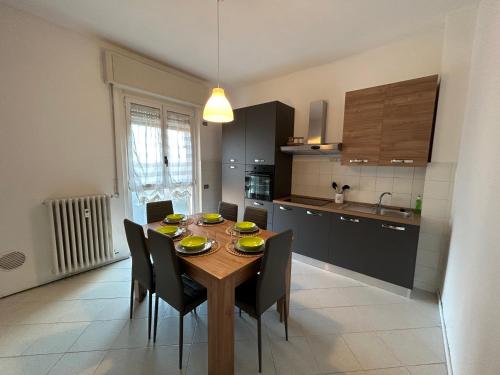 eine Küche mit einem Holztisch mit Stühlen und einem Esszimmer in der Unterkunft Attico Bellavista in Novate Milanese