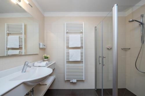 ティローロにあるHotel Panoramaの白いバスルーム(シャワー、シンク付)
