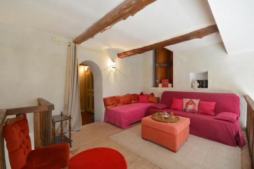 een woonkamer met een roze bank en een tafel bij Le Mas Saint Pierre - 10 personnes in Cabannes