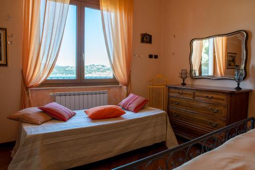 a bedroom with a bed and a mirror and a window at il mare di nonna Vi in Lerici