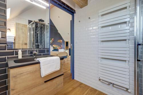 a bathroom with a sink and a mirror at Un nid dans la Grange - Maison avec jacuzzi et sauna 