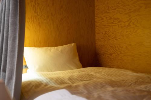 a bedroom with a bed with a pillow and a window at KIRO Hiroshima by THE SHARE HOTELS in Hiroshima