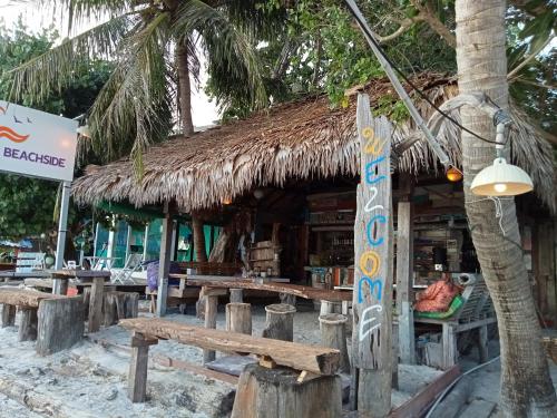 a restaurant on the beach with a slam hut w obiekcie Chareena Beachside w mieście Ko Lipe