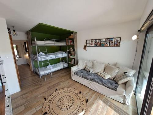 a living room with a couch and bunk beds at T2 avec terrasse à La Fossette in Le Lavandou