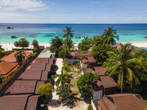 an aerial view of a beach with houses and palm trees at Chareena Beachside in Ko Lipe