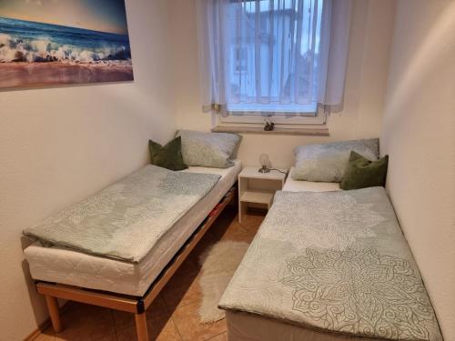 two beds in a small room with a window at Strandperle in Ueckeritz