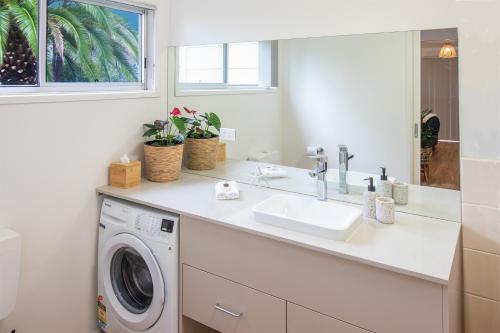 a bathroom with a sink and a washing machine at Coola studio in Mallacoota