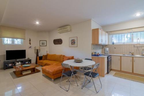 eine Küche und ein Wohnzimmer mit einem Tisch und einem Sofa in der Unterkunft Appartment in Nea Erithrea in Athen