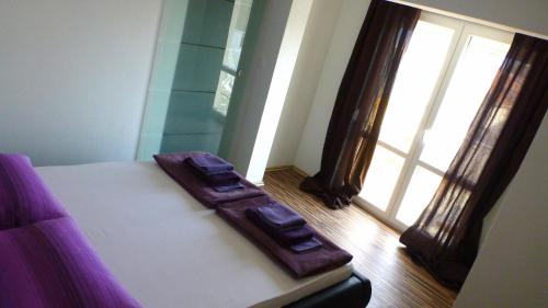 a bedroom with a bed with two brown leather seats at Apartments Milas in Trogir