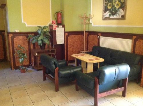 a waiting room with a couch and chairs and a table at Club Torony Hotel in Torony