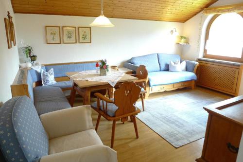 a living room with a table and a blue couch at Haus Schmidberger in Schneizlreuth