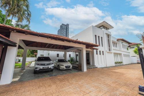 two cars parked in front of a house at Tropical Bliss Luxe 5BR 30Pax Private Pool Villa KL by Verano in Kuala Lumpur